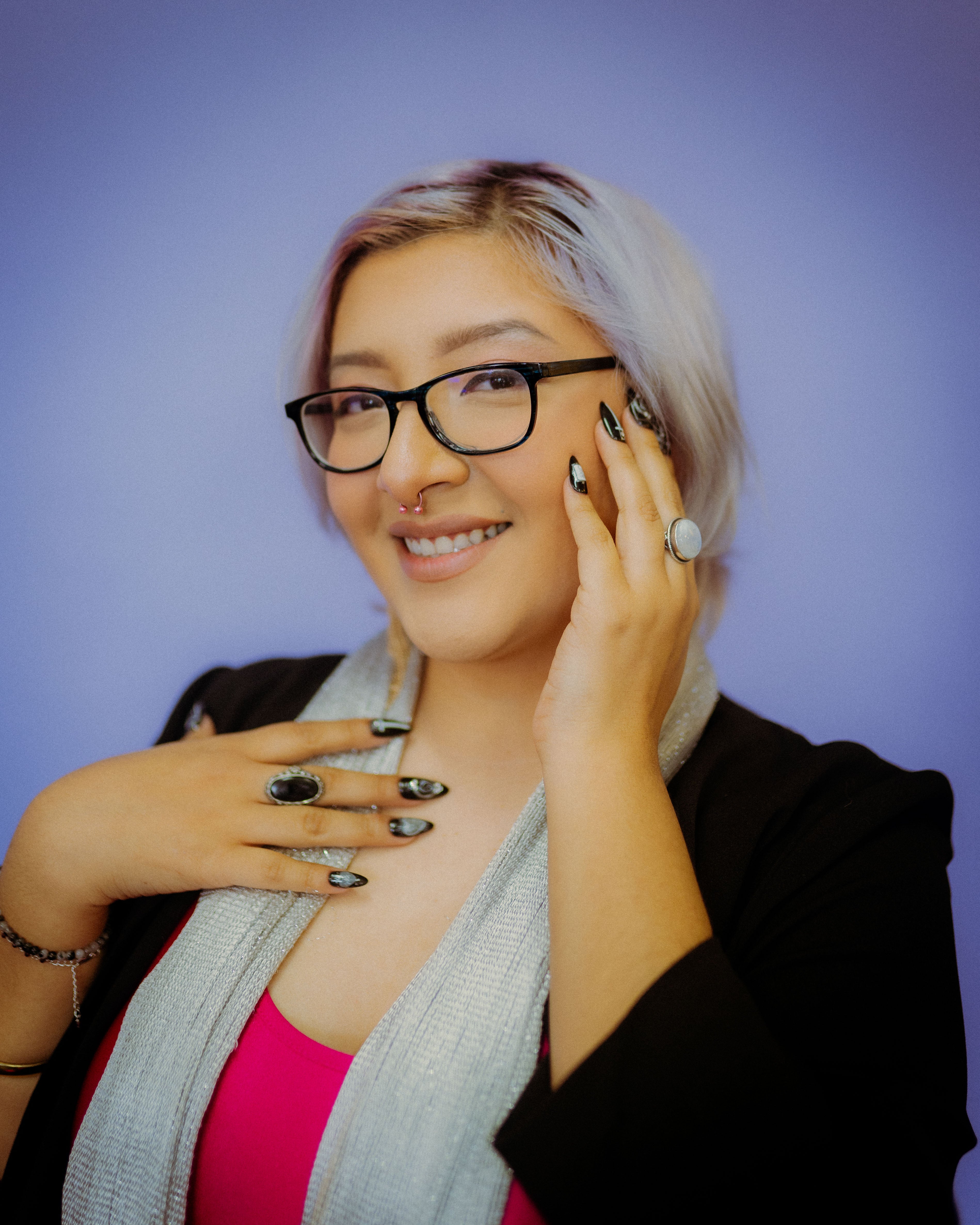 A portrait photo of nail artist Karina Hernandez showing off her new faux nails set, Mea Culpa, which are black and white with a gothic aesthetic